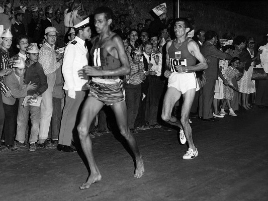 Abebe Bikila running barefoot at the 1960 Olympics in Rome.  The Ethiopian native took gold in that race, crossing the finish line in a record time of 2:15:16.